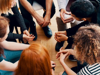 Eine Gruppe von Jugendlichen sitzt in einem Sesselkreis und ist in ein Gespräch vertieft. 