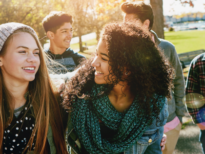 Teenager unterschiedlicher Ethnien und Geschlechts lächeln in die Kamera. BIld für den Vortrag "Grundlagen Sucht in Kindheit und Jugendalter" 