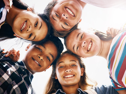 Kinder unterschiedlicher Ethnien lächeln in die Kamera. Bild für das Webinar "Wie schütze ich mein Kind vor Sucht" 